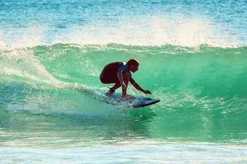Surfeur sur une vague turquoise