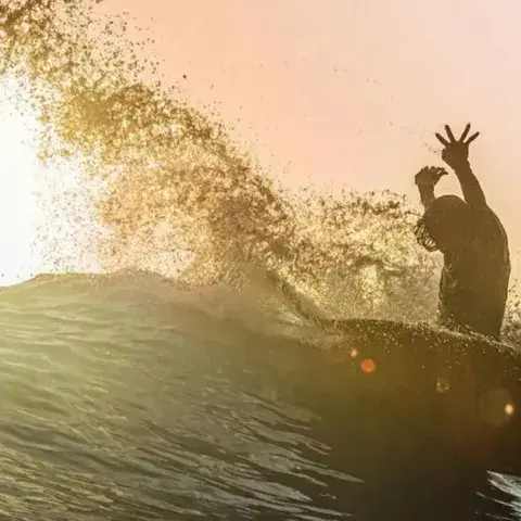Surfeur à contre-jour sur une vague