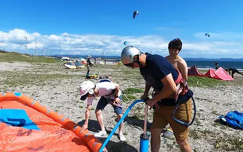Préparation d'un kite sur la plage pendant un cours
