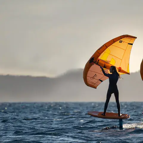 Deux riders de wing foil sur l'eau avec leurs ailes