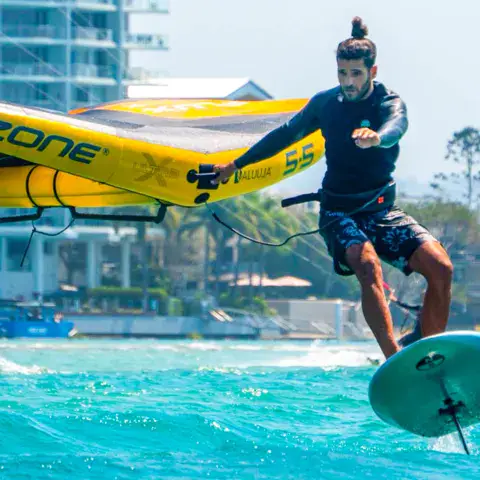 Rider de kitefoil devant des immeubles en bord de mer
