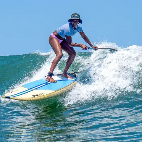 Rider debout sur une planche de paddle dans une vague