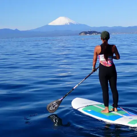 Une personne en stand up paddle, le mont Fuji au loin