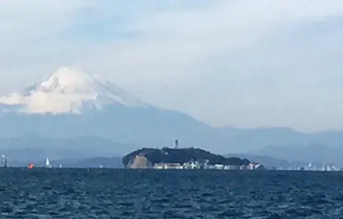 Des windsurfeurs sur la baie, le mont Fuji et l'île d'Enoshima au fond