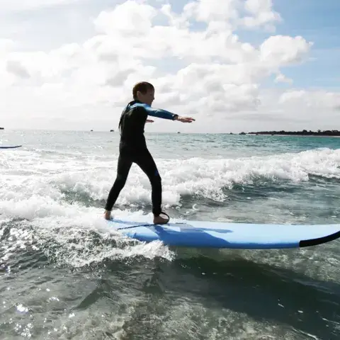Élèves debout sur des planches d'apprentissage dans l'eau