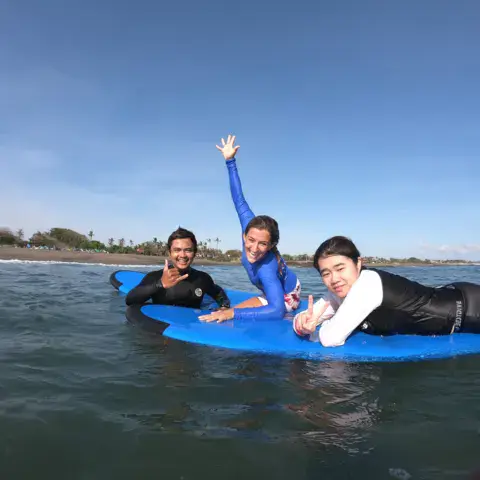 Trois personnes sur une planche en mousse