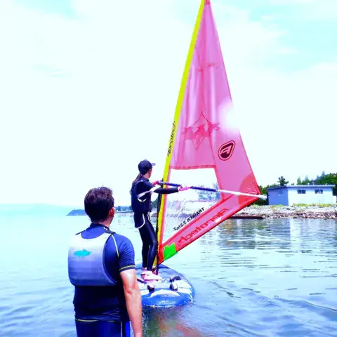 Un instructeur suit un élève sur l'eau peu profonde