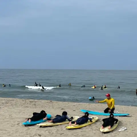 Planches jaunes et élèves en combinaison au bord de l'eau
