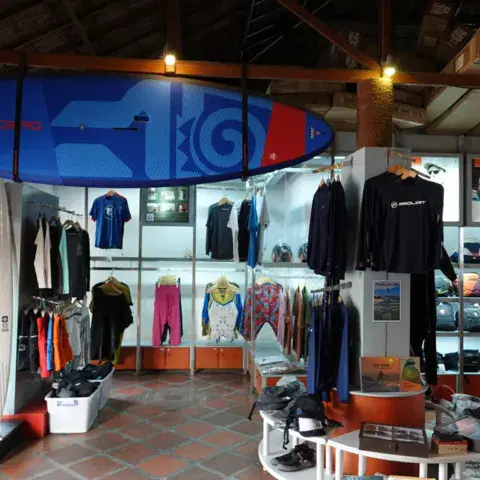 Rayon de la boutique avec planches de surf et vêtements