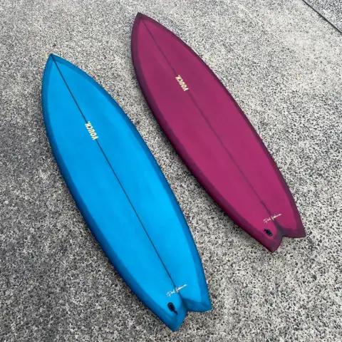 Deux planches finies, un twin bleu et un fish bordeaux