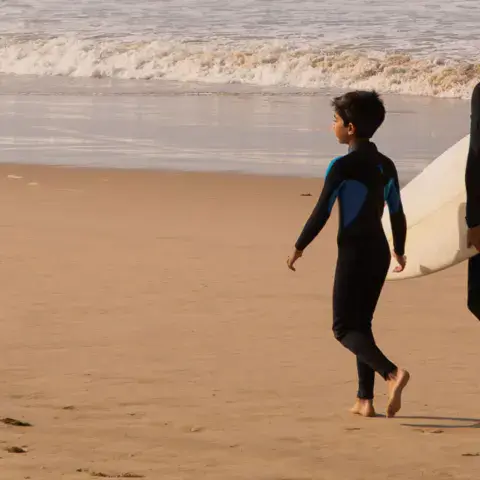 Une famille avec des planches au bord de l'eau