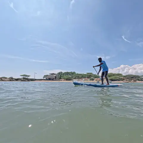 Une personne en stand up paddle sur l'eau peu profonde