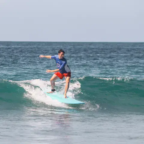 Un surfeur sur une vague verte