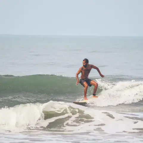 Un surfeur debout sur sa planche
