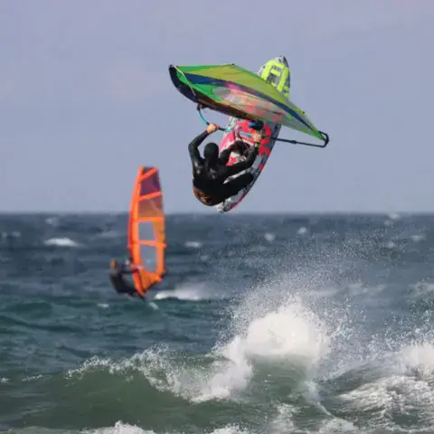 Saut de windsurfeur dans les vagues