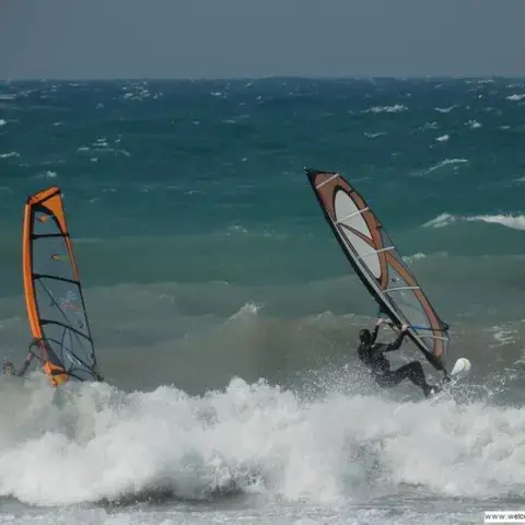Deux windsurfeurs dans la houle, par vent fort