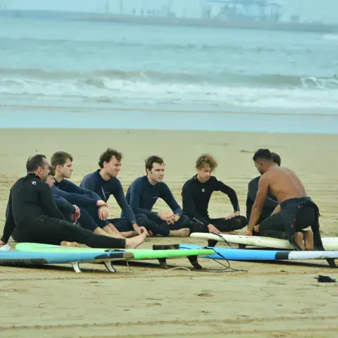 Briefing en groupe sur la plage avant la session