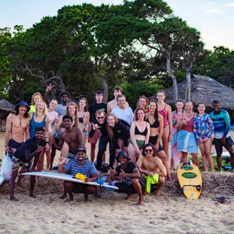 Grand groupe de surfeurs du camp sous les arbres