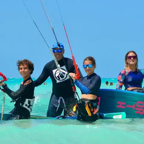 Groupe d'élèves et de moniteurs dans l'eau, avec leurs kites