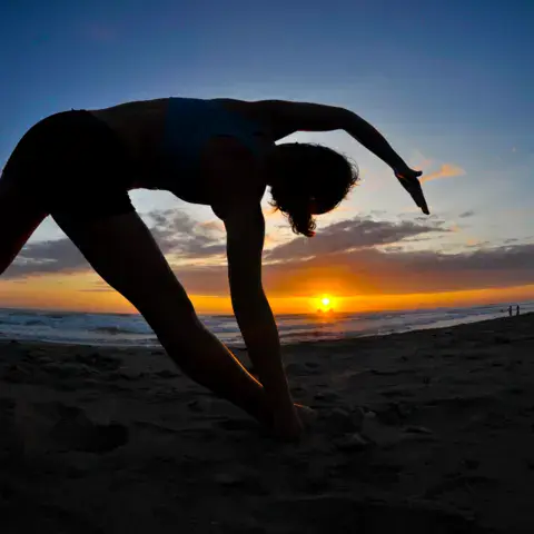 Séance de yoga sur la plage au coucher du soleil