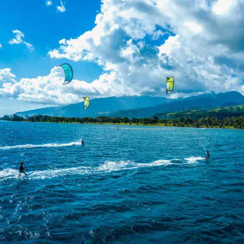Kitesurfeurs dans le lagon, montagne en arrière-plan