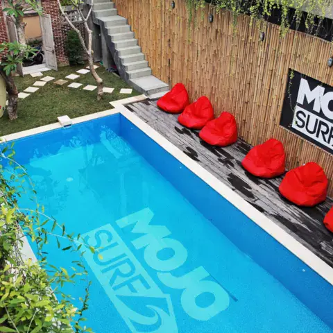 Piscine avec coin détente et poufs rouges
