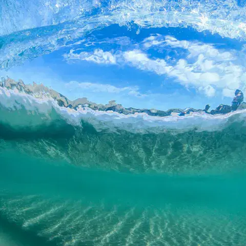 Vague vue de l'intérieur, au-dessus d'un fond de sable