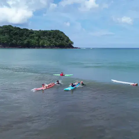 Vue aérienne d'élèves à l'eau sur leurs planches