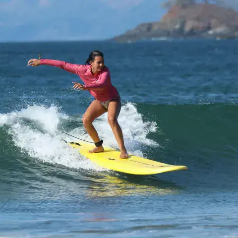 Surfeuse sur une planche en mousse jaune