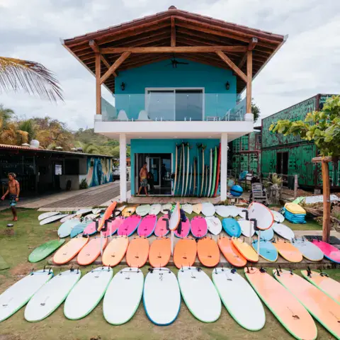Planches de surf alignées devant le bâtiment du camp
