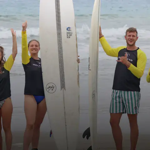 Moniteurs de l'école avec leurs planches sur la plage