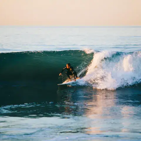 Surfeur sur une vague en fin de journée
