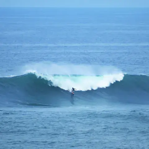 Surfeur seul face à une vague