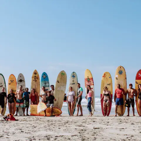 Groupe alignant les planches sur la plage