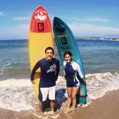 Deux élèves avec leurs planches au bord de l'eau
