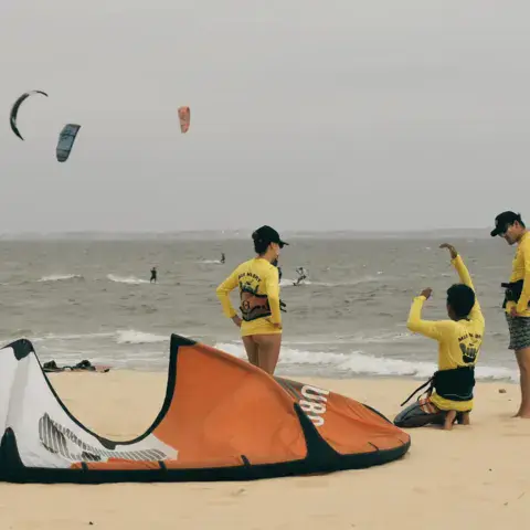 Un groupe en cours sur la plage, avec les ailes déployées