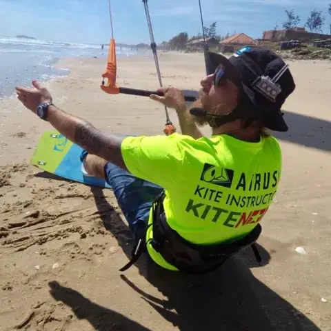 Un moniteur explique le contrôle de l'aile sur la plage