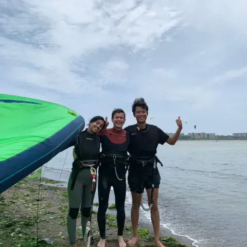 Élèves et moniteur sur la plage avec une aile de kite