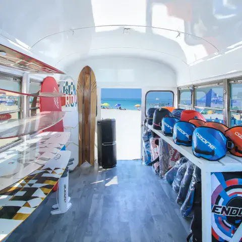Intérieur d'un bus aménagé avec du matériel de kitesurf