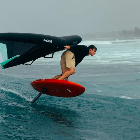 Rider en wing foil sur une vague