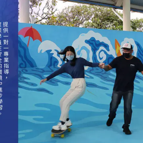 Cours de surf-skate avec un moniteur devant la fresque du centre