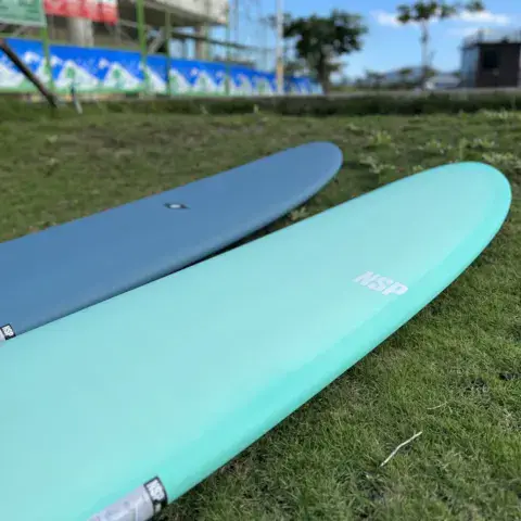Deux planches de surf posées sur l'herbe