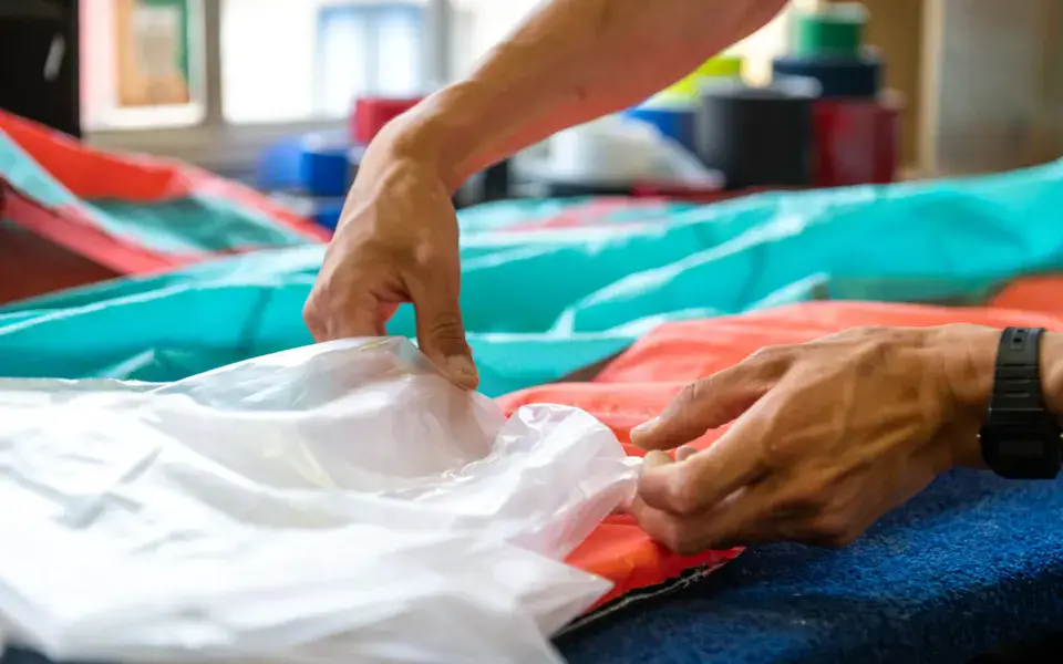Réparation d'une aile de kitesurf à l'atelier