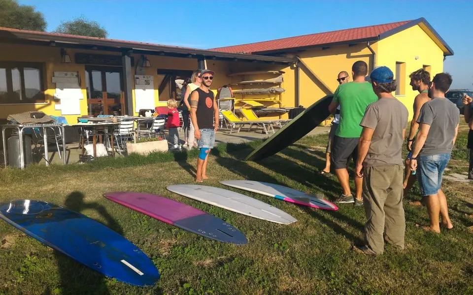 Briefing d'un groupe devant la base de l'école, planches de surf au premier plan