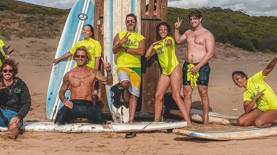 Groupe de surfeurs avec leurs planches sur la plage