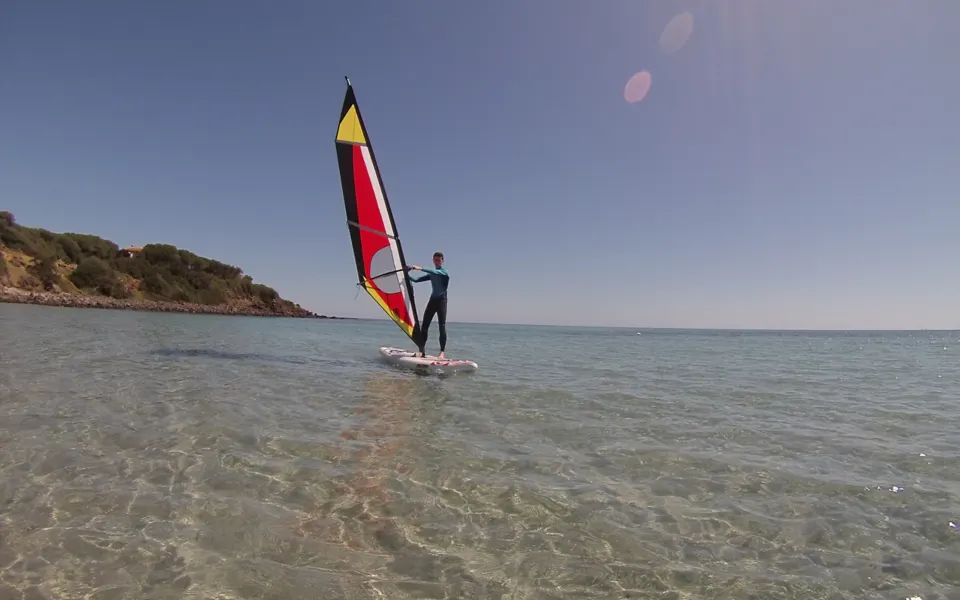 Windsurfeur sur une eau transparente et peu profonde