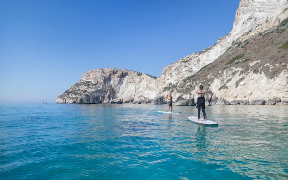 Deux pratiquants de stand up paddle face aux falaises calcaires de Cagliari