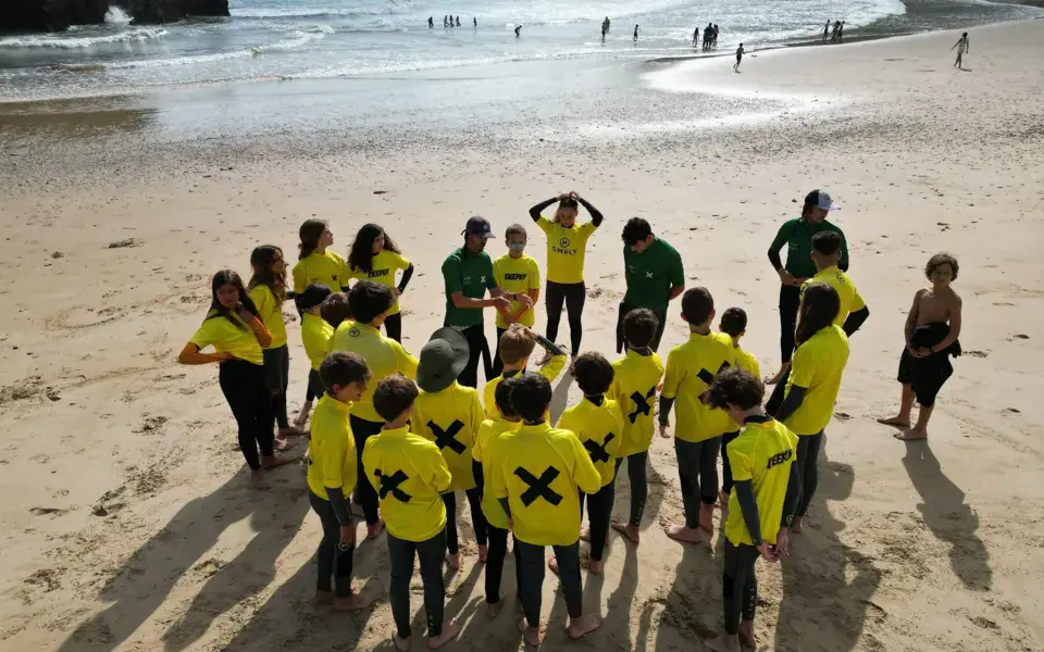 Groupe d'élèves en maillots jaunes et verts sur la plage