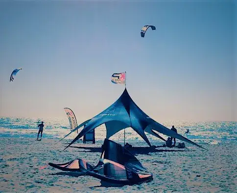 Tente de l'école sur la plage, kites dans le ciel