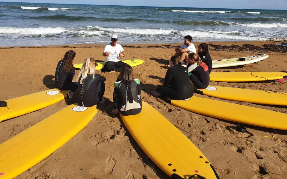 Briefing sur la plage avec planches de surf jaunes